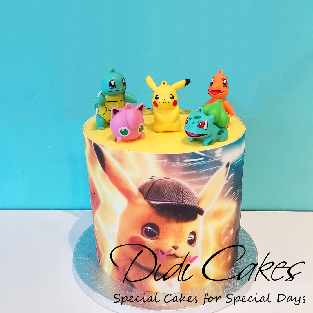 A round birthday cake with Pokemon characters decorations on top, primarily in yellow, green, and blue colors,